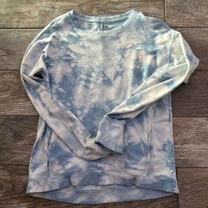 Sky blue tie die hoodie with pockets and holes for thumbs in the sleeves.